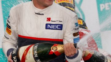 Sergio Pérez descorcha el champán en podio del Gran Premio de Malasia.