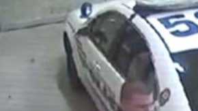 Zimmerman mira hacia abajo mientras habla con un policía.