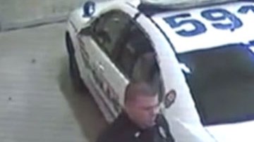 Zimmerman mira hacia abajo mientras habla con un policía.