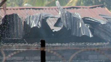 Reclusos hondureños lanzan desde el tejado agua para poder sofocar el incendio en el interior del Centro Penal de San Pedro Sula, al norte de Honduras.