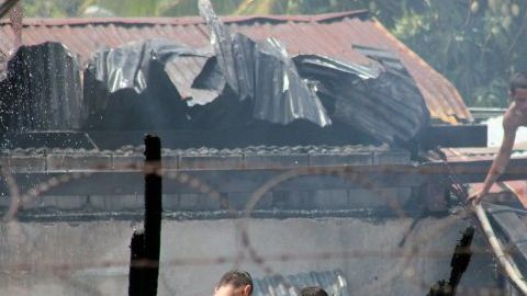 Reclusos hondureños lanzan desde el tejado agua para poder sofocar el incendio en el interior del Centro Penal de San Pedro Sula, al norte de Honduras.