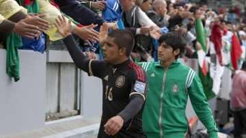 Los jugadores de México Miguel Ponce (i) y Alan Pulido (d) saludan al público después de jugar contra Honduras en en el estadio Home Depot Center en Los Ángeles, el 25 de marzo.