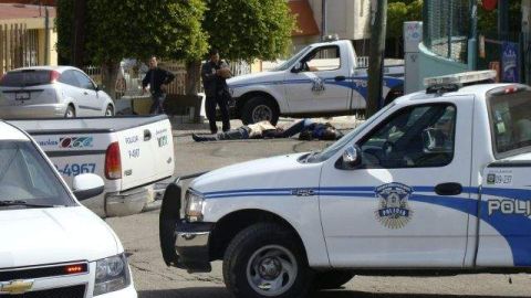 Policías municipales resguardan la zona donde dos escoltas fueron asesinados por una presunta víctima de secuestro.