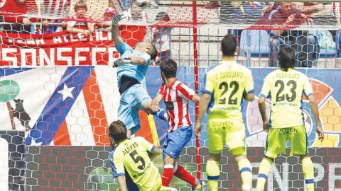 Diego (centro) toma un rebote del larguero y con golpe de cabeza bate a Moyá para anotar el segundo gol de Atlético de Madrid sobre Getafe.