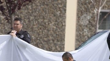 Peritos forenses trabajan la escena donde cayeron muertas  varias de las víctimas fatales del exestudiante universitario.