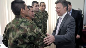 El presidente de Colombia, Juan Manuel Santos (derecha), visitó ayer a policías  y militares quienes fueron liberados por la guerrilla colombiana.