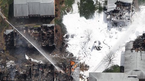 Los bomberos se mantienen apagando el incendio provocado por el accidente de la nave militar en Virginia Beach.