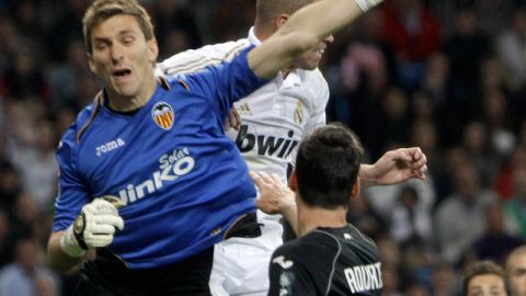 Vicente Guaita, portero del Valencia, despeja el balón ante el acoso de Pepe en el juego de ayer disputado en el Santiago Bernabéu.