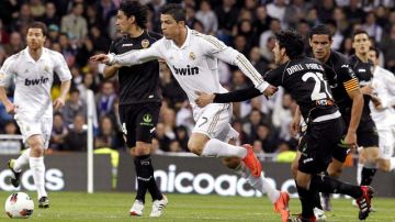 El delantero portugués del Real Madrid Cristiano Ronaldo (c) conduce el balón entre los jugadores del Valencia.