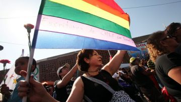 Una mujer sostiene una bandera arco iris en el funeral de Daniel Zamudio, en Santiago, Chile.