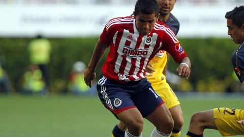 Paul Aguilar (d) de América disputa el balón con Miguel Ponce (i) de Chivas, durante el partido realizado el 8 de abril de 2012.