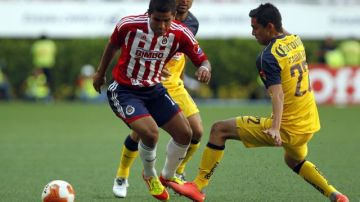 Paul Aguilar (d) de América disputa el balón con Miguel Ponce (i) de Chivas, durante el partido realizado el 8 de abril de 2012.