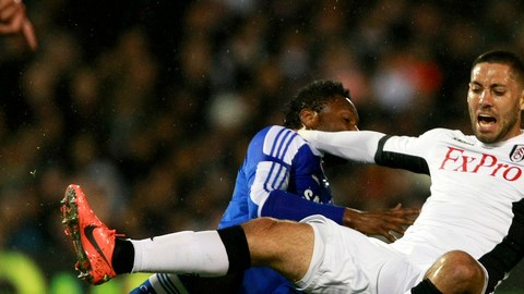 John Obi Mikel (izq.), de Chelsea, le comete falta a Clint Dempsey del Fulham. Dempsey anotó el gol del empate en el partido jugado ayer.