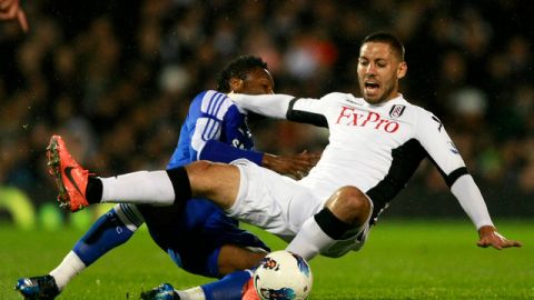 John Obi Mikel (izq.), de Chelsea, le comete falta a Clint Dempsey del Fulham. Dempsey anotó el gol del empate en el partido jugado ayer.
