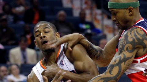 Cory Higgins (izquierda), de los Bobcats de Charlotte y James Singleton (derecha) de los Wizards de Washington disputan una bola suelta durante el juego de ayer.