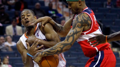 Cory Higgins (izquierda), de los Bobcats de Charlotte y James Singleton (derecha) de los Wizards de Washington disputan una bola suelta durante el juego de ayer.