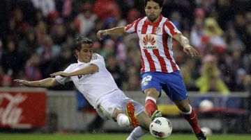 Diego (d) del Atlético Madrid, es objeto de falta por parte del portugués Fabio Coentrao, del equipo 'merengue', en el derbi madrileño disputado ayer en el estadio Vicente Calderón y que ganaron los líderes de La Liga.