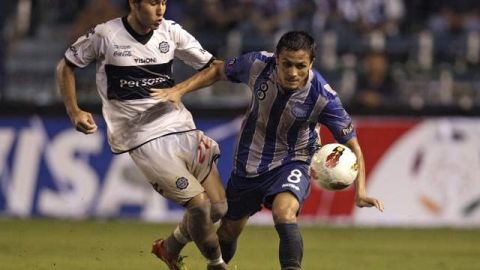 Marcos Mondaini, de Emelec (d), pelea la pelota con Fabio Caballero de Olimpia, durante el partido que disputaron en Guayaquil el 9 de febrero pasado.