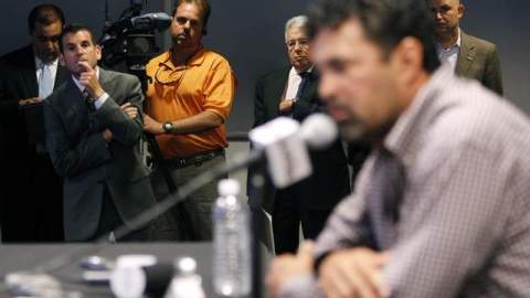El presidente de los Marlins, David Samson (izq.), escucha al piloto del equipo de Miami, el venezolano Ozzie Guillén, excusarse públicamente por elogiar a Fidel Castro, durante una concurrida conferencia de prensa.