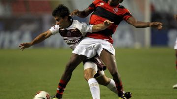 Williams (der.) -del Flamengo, de Brasil- disputa el balón con Carlos Araújo de Lanús de Argentina en el partido que ganaron los brasileños 3-0.
