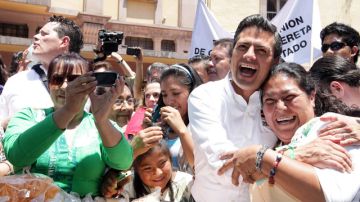 El candidato presidencial de la coalición Compromiso por México, Enrique Peña Nieto recibe la ovación de seguidores durante su visita a Querétaro.