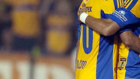 Carlos Salcido (izq.) y Alan Pulido se abrazan ante un jugador de Chivas, luego de su victoria.