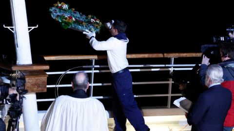 Un miembro de la tripulación del MS Balmoral Titanic arroja una corona de flores  durante una ceremonia conmemorativa, con motivo del 100 aniversario  del desastre del Titanic, en el lugar del naufragio en el Océano Atlántico.