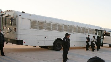 Agentes de inmigración vigilan los buses donde son llevados los indocumentados que van a ser deportados.