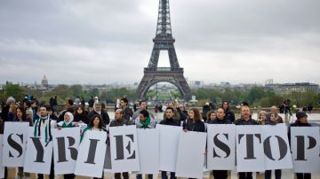 Activistas sostienen carteles que dicen "Siria para ya", como parte de la campana  contra la violencia.
