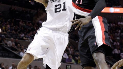 Tim Duncan (21), de San Antonio, se eleva   frente a J.J. Hickson, de Portland.