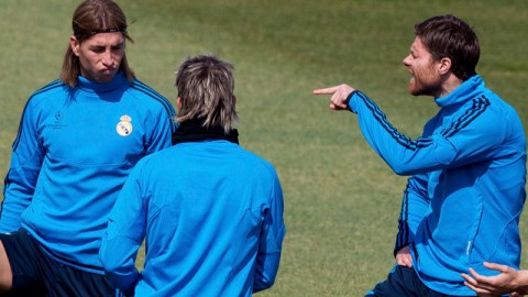 Xabi Alonso (der.) se dirige a Sergio Ramos (izq.) en la práctica efectuada ayer por el Real Madrid con miras a su crucial encuentro de hoy con Bayern Munich.