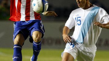 Jorge Mendoza (izq.), de Paraguay, intenta pasar frente a  la marcación de    Manuel León, de Guatemala, en un trámite del partido disputado la noche del miércoles.