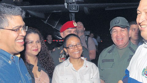 El presidente Hugo Chávez aparece sonriente rodeado de algunos  de sus ministros a su llegada al aeropuerto de Maiquetia donde no habló con la prensa.