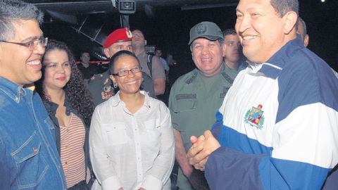 El presidente Hugo Chávez aparece sonriente rodeado de algunos de sus ministros a su llegada al aeropuerto de Maiquetia donde no habló con la prensa.