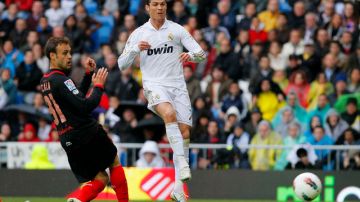 El artillero portugués Cristiano Ronaldo (der.) convierte una de las anotaciones del Real Madrid ayer en su cómoda  victoria de 3-0 sobre el Sevilla.