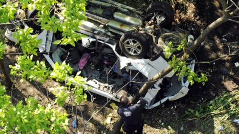 Policias investigan el van destruido después de haberse precipitado por un barranco, cuando venía por la Bronx River Parkway, ayer, en Nueva York.