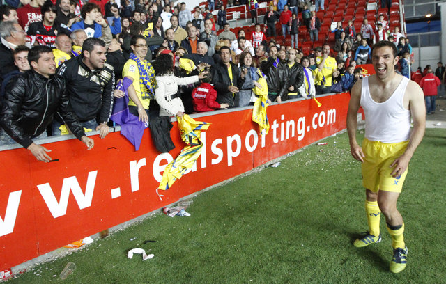 Carlos Marchena (der.), celebra con los fanáticos del Villarreal el importante triunfo como visitante 3-2 sobre el Sporting de Gijón.