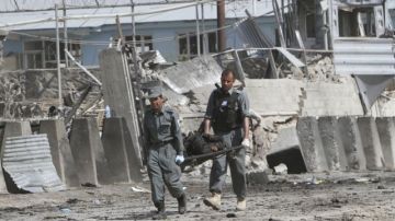 Policías afganos extraen un cuerpo del lugar donde se producjo el atentado.