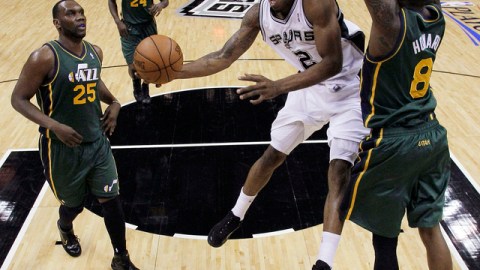 Kawhi Leonard (2), de San Antonio, trata de encestar ante la marca de Josh Howard (8) y Al Jefferson (25), del Jazz de Utah.