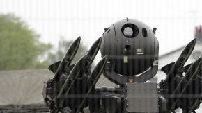 Un hombre pasa cerca de una batería de misiles Rapier. Este sistema de defensa forma parte de los ejercicios militares antes de los JO.