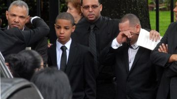 Juan González (izq.) padre de los menores fallecidos en el accidente, es acompañado por su hijo mayor Jonel, a la salida de la iglesia St. Raymond.