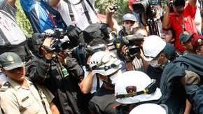 Miembros de la policía retiran uno de los cuerpos encontrados en el incendio.