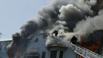 Bomberos de San Francisco combaten un incendio en un edificio residencial y comercial en la esquina de las calles Valencia y Duboce en San Francisco.