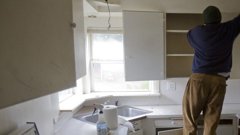 Un hombre hace reparaciones en la cocina de su vivienda.