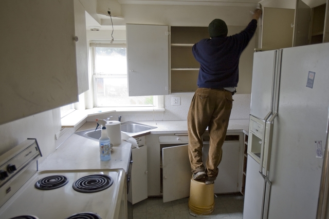 Un hombre hace reparaciones en la cocina de su vivienda.