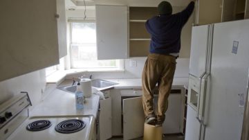 Un hombre hace reparaciones en la cocina de su vivienda.