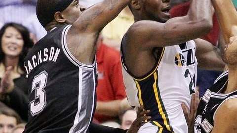 Stephen Jackson (3) y Tim Duncan (der.), de San Antonio, marcan a Paul Millsap (centro), de Utah, en el juego de ayer.