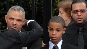 Juan González (izq.) padre de las menores fallecidos en el accidente es acompañado por su hijo mayor Jonel a la salida de la iglesia St. Raymond.