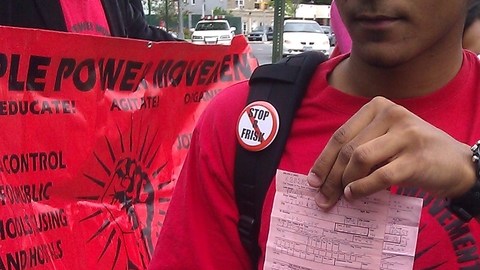 Malik Ayala, mientras participaba en la marcha de ayer,  muestra la citación de la policía por conducta desordenada.