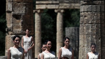 La sacerdotisa (der.) enciende la flama olímpica utilizando un espejo concavo, ayer, en el último ensayo para la gran ceremonia de hoy.